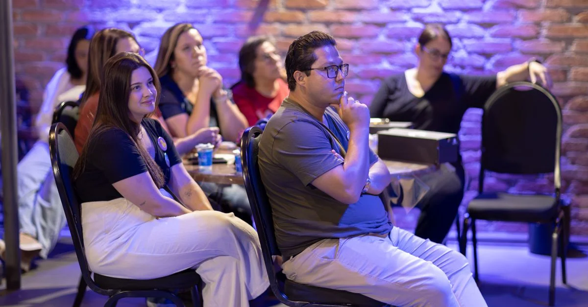 Des membres d'un public attentif écoutent pendant un séminaire ou un atelier en salle.