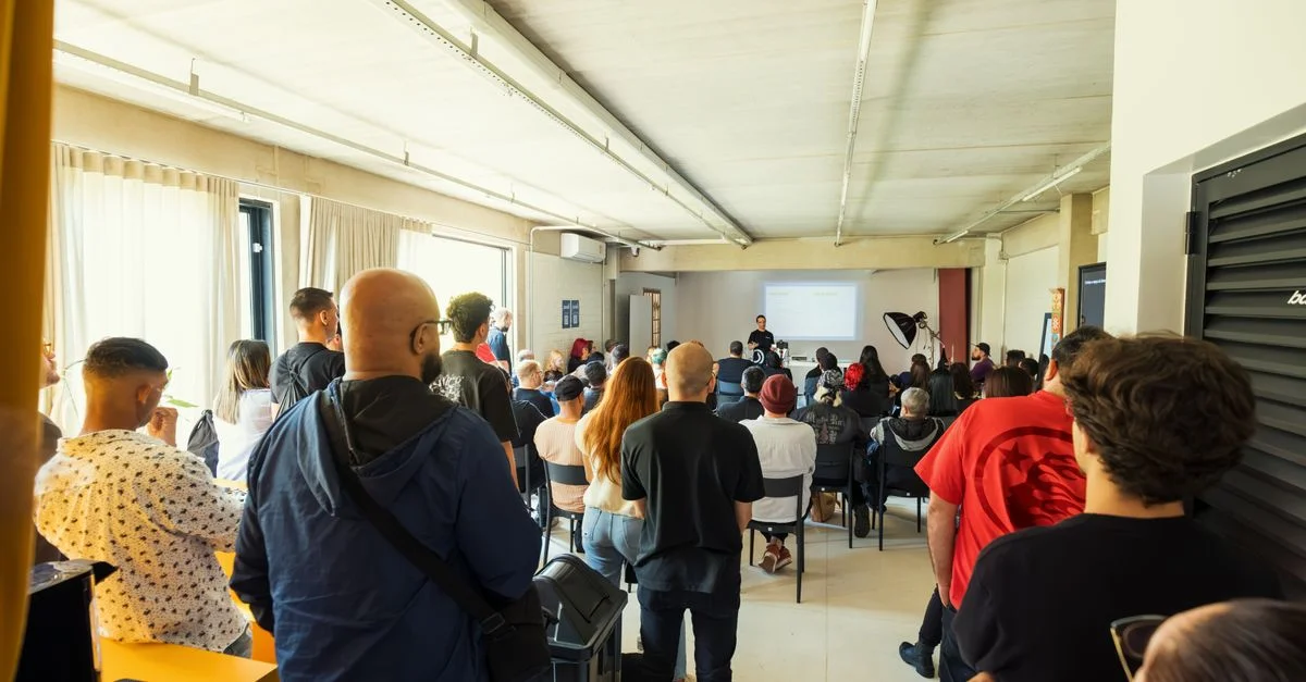 Un groupe diversifié participant à un séminaire dans un cadre intérieur moderne et lumineux.