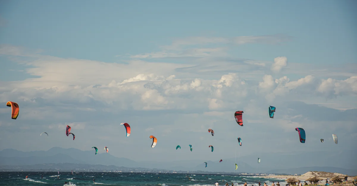 Des kitesurfeurs vibrants profitent d'une journée ensoleillée sur la plage de Lefkada, en Grèce.