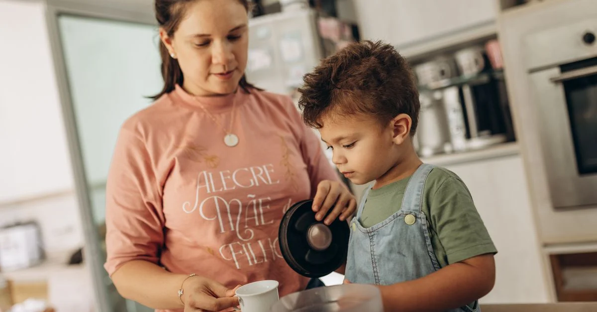 Mère et fils profitant de leur temps dans la cuisine, versant une boisson ensemble.